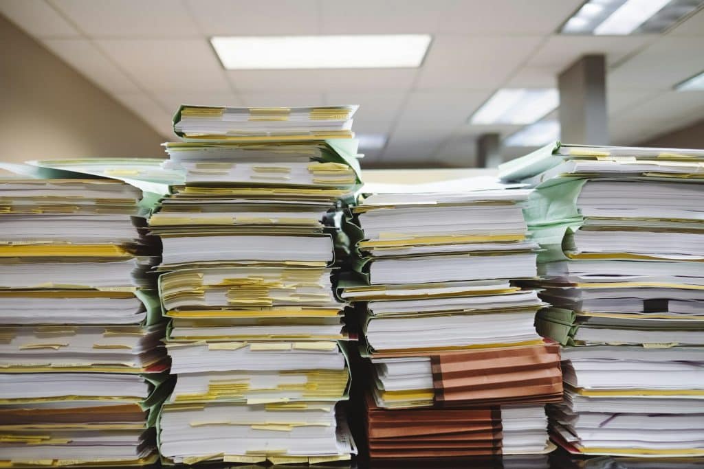 Stacks of paper documents illustrating vendor contracts and invoice analysis