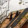 Construction workers installing roofing materials on a house