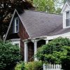 Detached suburban house with dormer windows and landscaped front yard; illustrative image for Freddie Mac delinquent loan auction