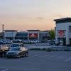 Shopping center and parking area at dusk, illustrating grocery-anchored retail real estate