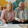 Older homeowners reviewing financial documents at home