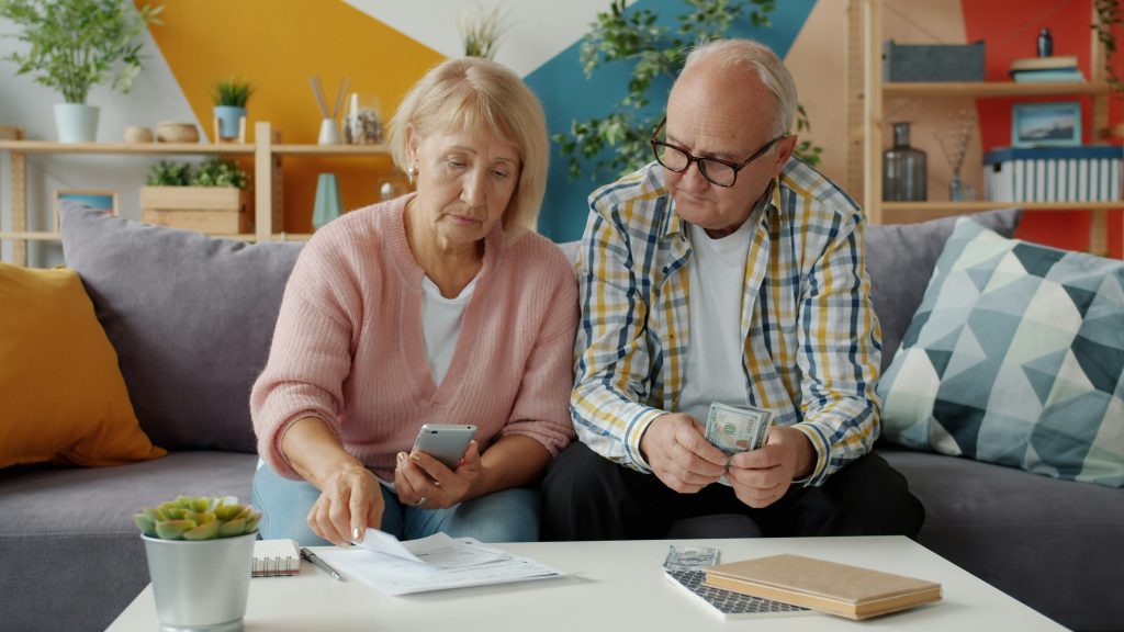 Older homeowners reviewing financial documents at home
