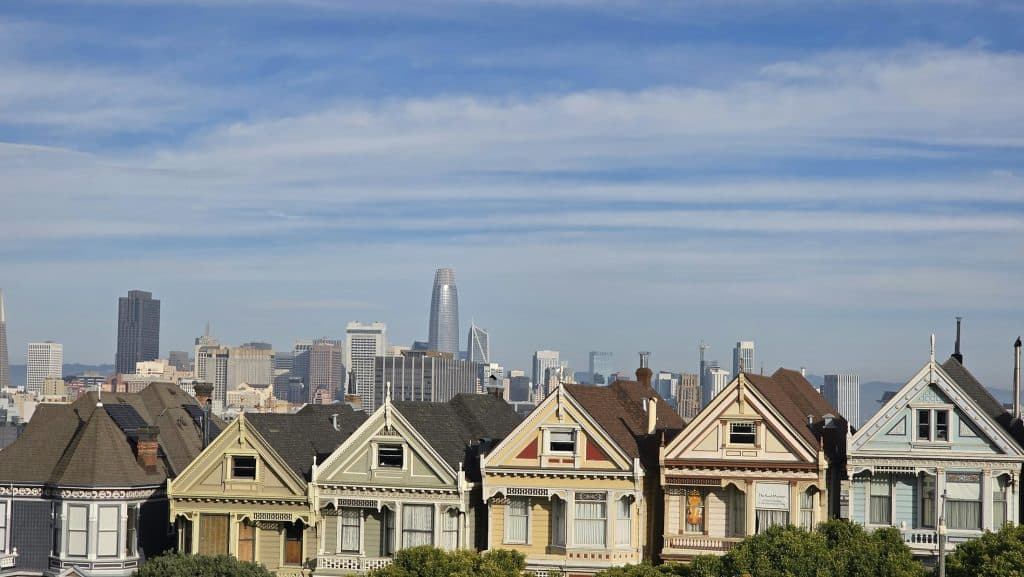 Victorian Painted Ladies homes in San Francisco with skyline in the background; illustrative image