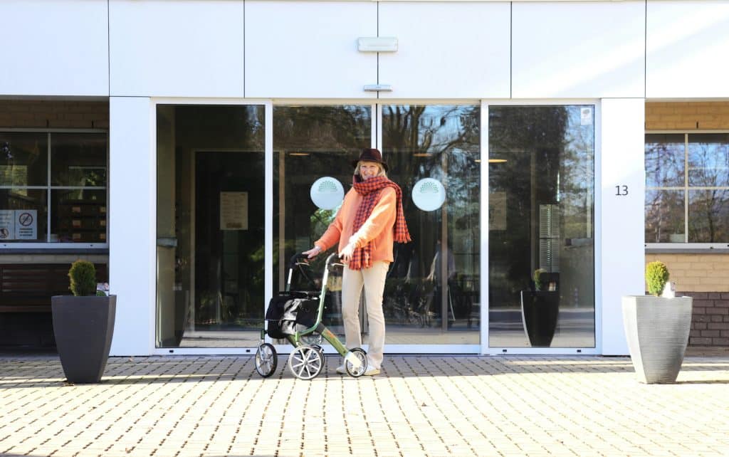 Senior resident entering a building, illustrative image for senior housing refinancing