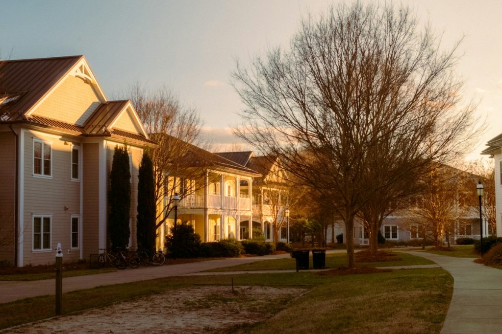 Residential community buildings and landscaped walking path in warm sunlight, illustrative image