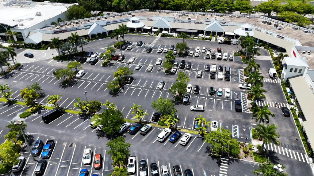 Aerial view of a retail shopping center parking lot, illustrative of commercial retail real estate