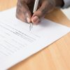 Person reviewing and signing documents, illustrative image for homebuyer commission settlement claim deadline