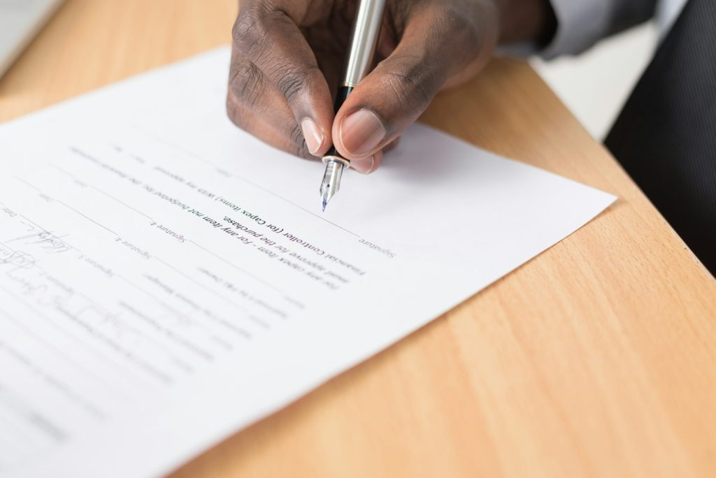 Person reviewing and signing documents, illustrative image for homebuyer commission settlement claim deadline