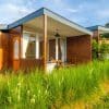 Small detached house in a green open landscape, illustrating the potential for factory-built starter homes