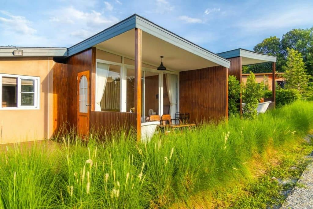 Small detached house in a green open landscape, illustrating the potential for factory-built starter homes