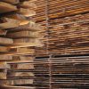 Stacks of lumber boards at a lumberyard, illustrating softwood lumber import duties