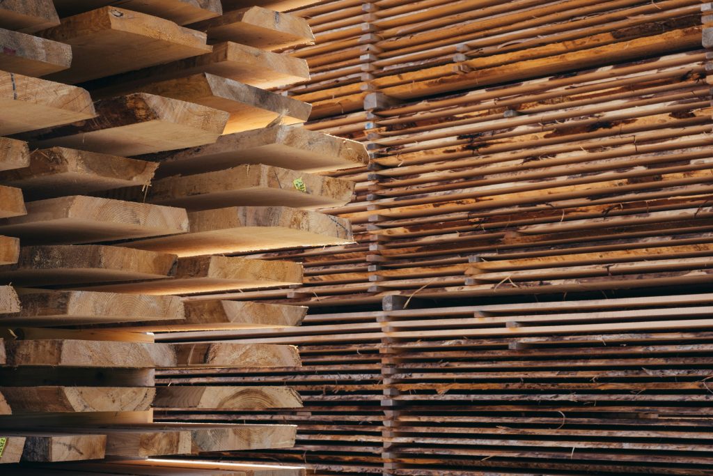 Stacks of lumber boards at a lumberyard, illustrating softwood lumber import duties