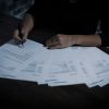 Person signing closing documents illustrating title and settlement production