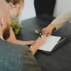 Homebuyers signing paperwork at a table, illustrative closing photograph